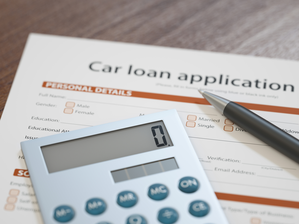 Auto financing documents with calculator showing how to manage negative equity car loans.